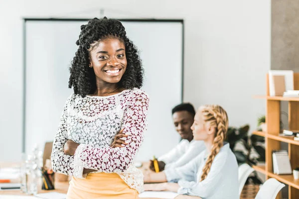 Portrait of smiling african american businesswoman standing at workplace during conference in office — Stock Photo