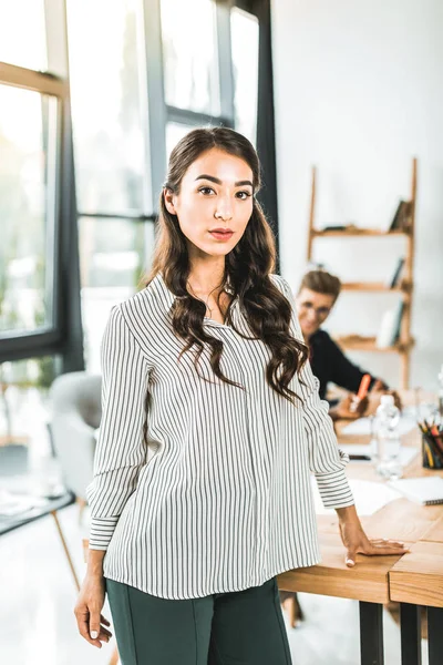 Portrait of beautiful asian businesswoman standing at workplace in office — Stock Photo