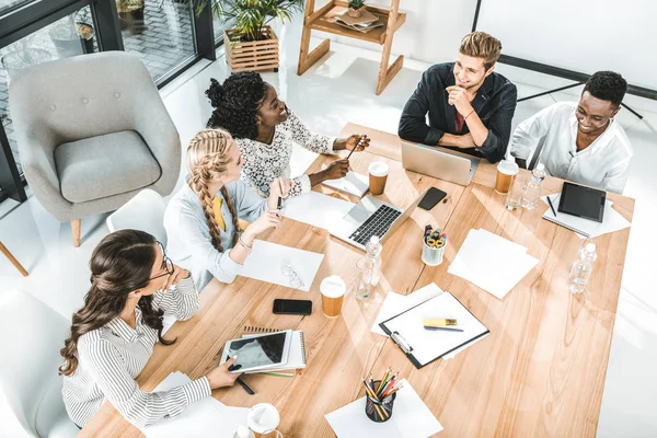 Blick aus der Vogelperspektive auf eine multikulturelle Gruppe von Geschäftsleuten, die über Arbeit im Büro diskutieren — Stockfoto