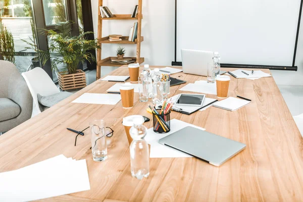 Empty business workplace with disposable cups, digital devices and papers in office — Stock Photo