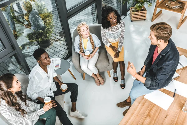 Vue en angle élevé de collaborateurs d'entreprises multiethniques se reposant pendant la pause café dans le bureau — Photo de stock