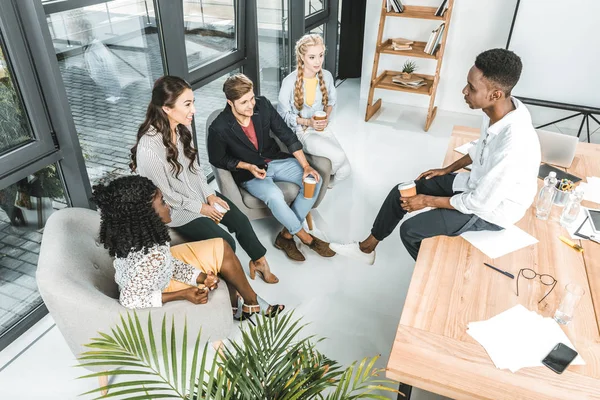 Groupe multiethnique de jeunes collègues d'affaires ayant une pause café au bureau — Photo de stock