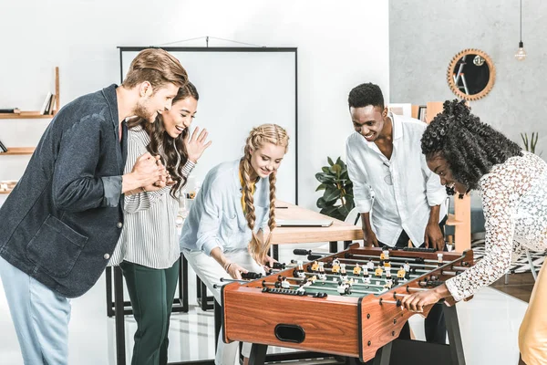 Uomini d'affari multiculturali e donne d'affari che giocano a calcio balilla insieme in ufficio — Foto stock