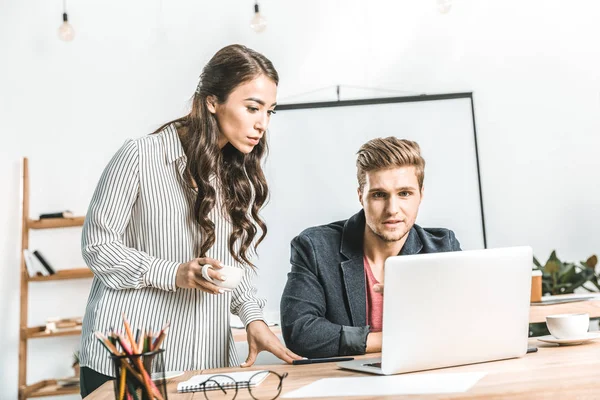 Portrait de gens d'affaires multiethniques travaillant ensemble sur un ordinateur portable au bureau — Photo de stock