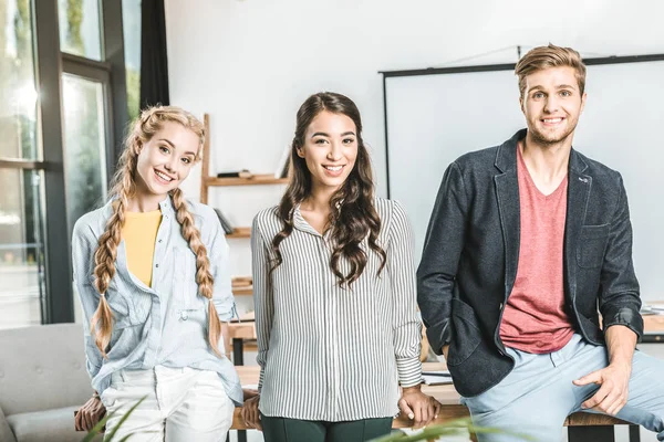 Portrait of stylish multiethnic business people standing together at workplace in office — Stock Photo