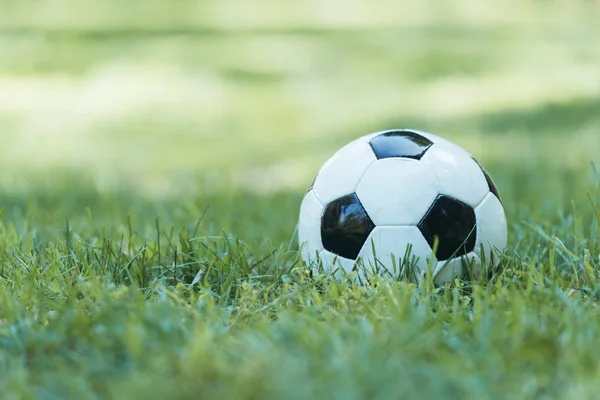 Vista close-up de bola de futebol de couro na grama verde — Fotografia de Stock