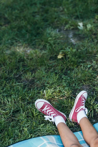 Low section of child resting on green grass in park — Stock Photo