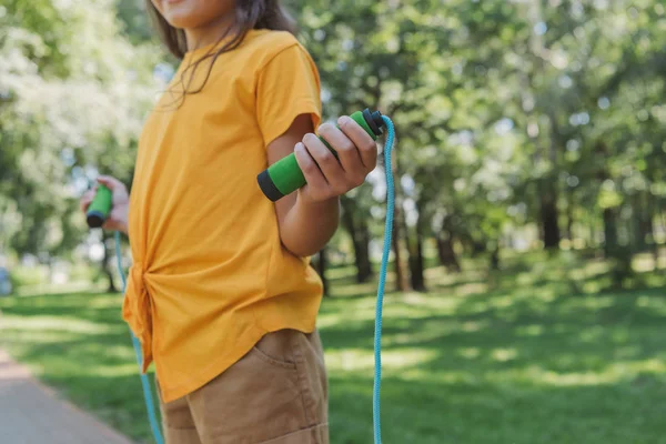 Recortado disparo de niño sosteniendo saltar la cuerda en el parque - foto de stock