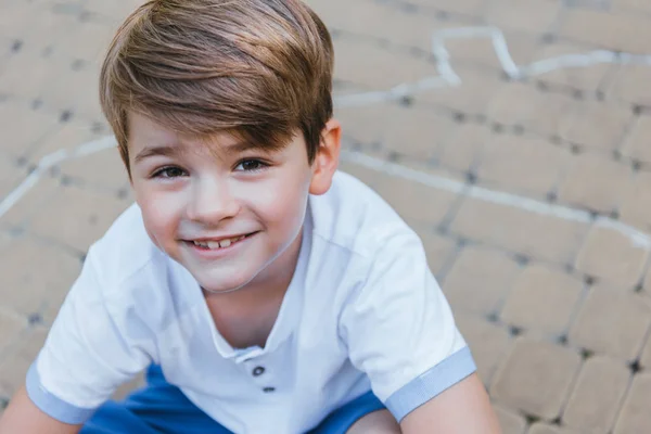 Vista de ángulo alto de adorable niño feliz sonriendo a la cámara - foto de stock