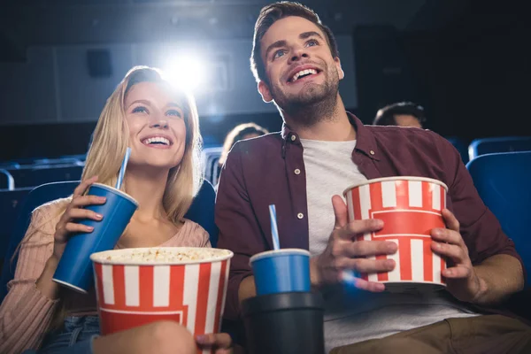 Happy couple with popcorn watching film together in cinema — Stock Photo