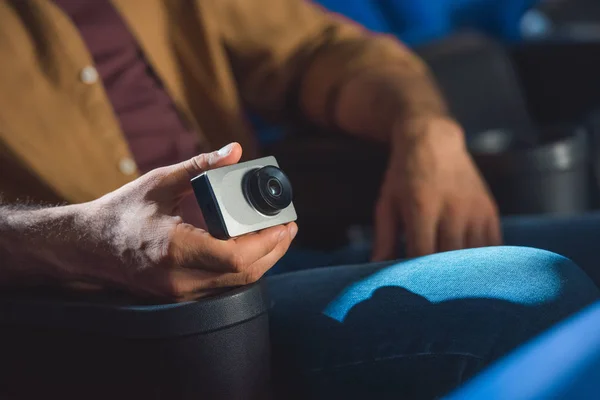 Vue partielle de l'homme avec une petite caméra vidéo filmant illégalement un film au cinéma — Photo de stock