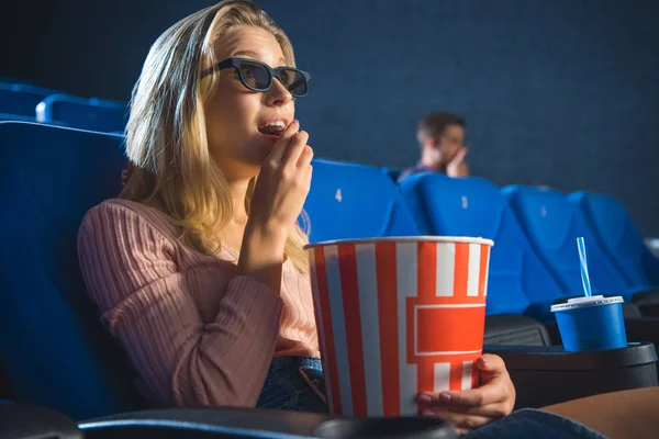 Vista laterale di giovane donna in occhiali 3d con popcorn guardare film da solo nel cinema — Foto stock