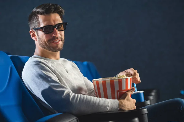 Seitenansicht eines lächelnden Mannes in 3D-Gläsern mit Popcorn im Kino — Stockfoto