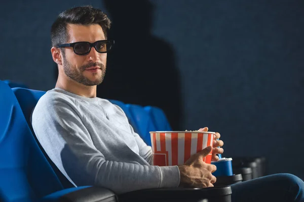 Side view of young man in 3d glasses with popcorn in cinema — Stock Photo