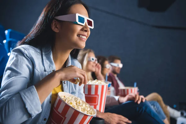 Sorridente donna asiatica in occhiali 3d con popcorn guardare film nel cinema — Foto stock
