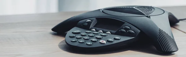 Close-up shot of conference phone on wooden table at office — Stock Photo