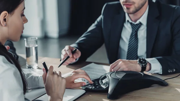 Cropped shot of businessman and businesswoman using conference at modern office — Stock Photo