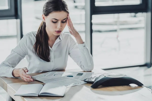 Jovem empresária sobrecarregada com dor de cabeça fazendo papelada no escritório — Stock Photo