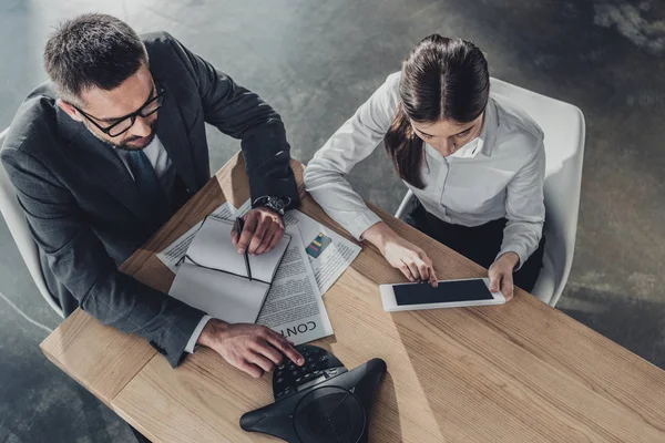 Blick aus der Vogelperspektive auf erfolgreiche Geschäftsfrau und Geschäftsfrau, die im modernen Büro mit Tablet und Lautsprecher zusammenarbeiten — Stockfoto