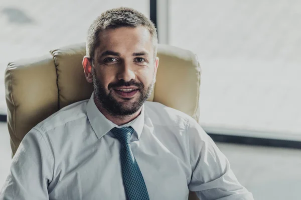 Ritratto ravvicinato di un bell'uomo d'affari sorridente che guarda la macchina fotografica — Foto stock