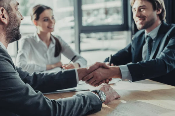 Бизнесмены пожимают друг другу руки во время встречи в современном офисе — стоковое фото