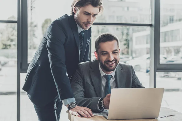 Handsome successful business people working with laptop together at modern office — Stock Photo