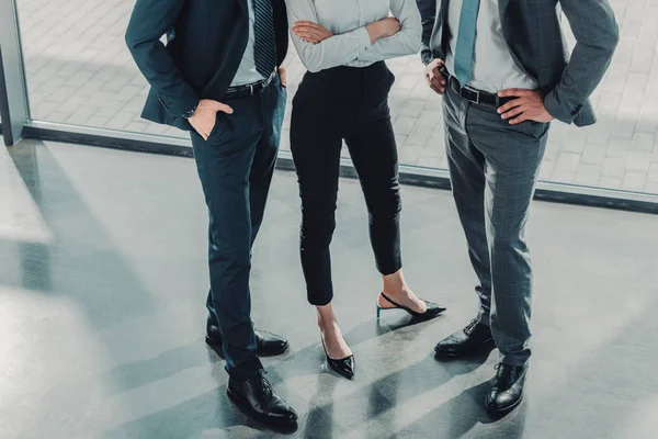 Recortado disparo de grupo de hombres y mujeres de negocios en la oficina moderna - foto de stock