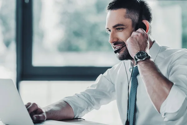 Hotline di supporto per adulti sorridente lavoratore con laptop sul posto di lavoro — Foto stock