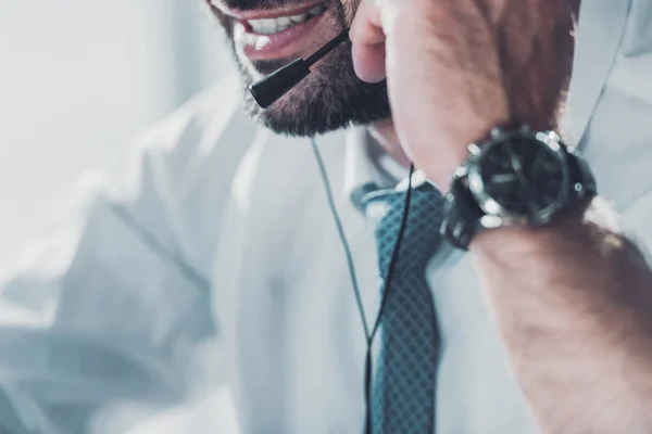 Обрізаний знімок працівника гарячої лінії в сорочці з краваткою, що розмовляє навушниками з мікрофоном — стокове фото