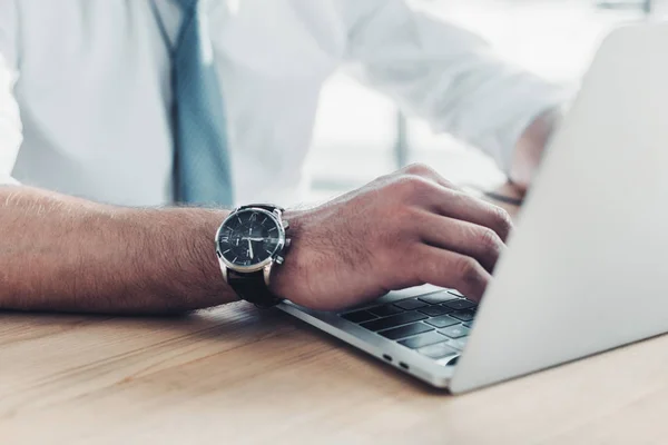 Recortado disparo de hombre de negocios utilizando portátil en el lugar de trabajo - foto de stock