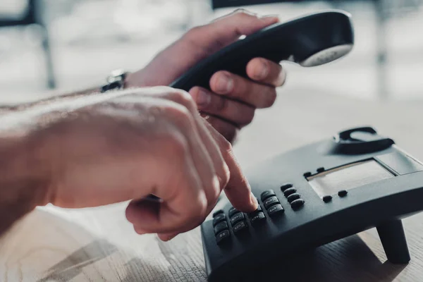 Tiro cortado de homem fazendo discagem telefone estacionário para fazer chamada — Fotografia de Stock