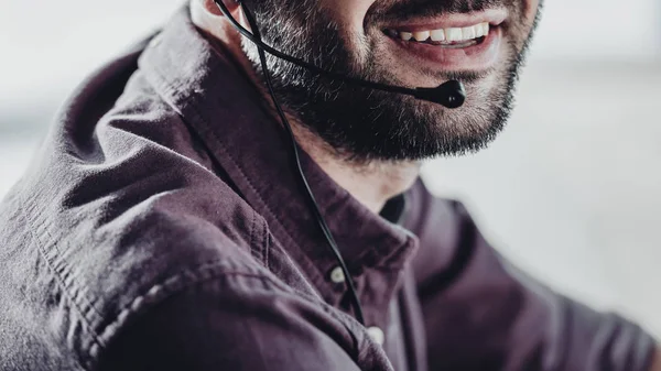 Обрізаний знімок усміхненого працівника колл-центру з мікрофоном — стокове фото