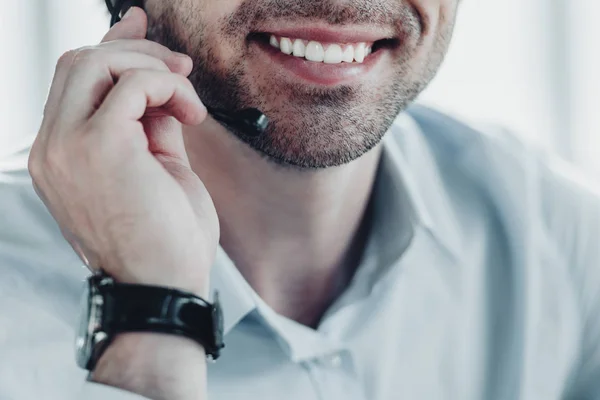 Recortado disparo de sonriente apoyo trabajador de línea directa celebración de micrófono - foto de stock