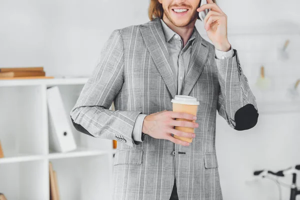 Обрезанный образ привлекательного бизнесмена, разговаривающего по смартфону в офисе — стоковое фото
