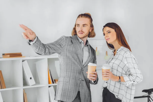 Homme d'affaires pointant sur quelque chose à son collègue pendant la pause café — Photo de stock