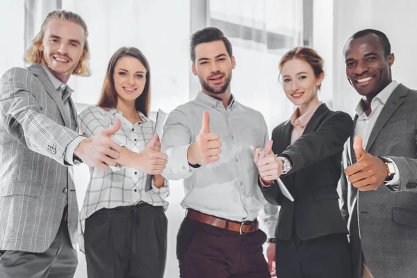 Smiling multicultural businesspeople showing thumbs up — Stock Photo