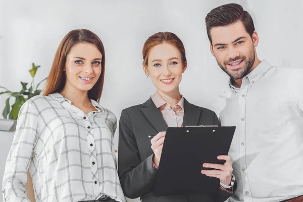 Smiling businesspeople standing and looking at camera — Stock Photo