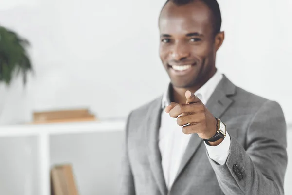 Smiling african american man pointing on camera — Stock Photo