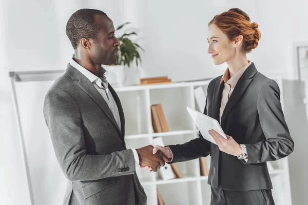 African american businessman and caucasian businesswoman shaking hands — Stock Photo