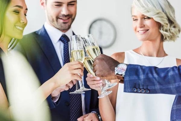 Multiethnische Geschäftsleute klirren mit Champagnergläsern im Büro — Stockfoto