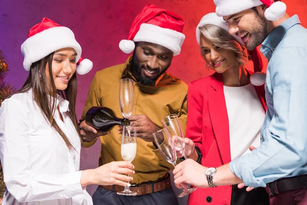 Empresário afro-americano derramando champanhe em colegas óculos em festa corporativa de ano novo — Fotografia de Stock