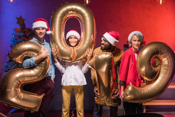 Young multicultural managers holding 2019 balloons at new year corporate party — Stock Photo