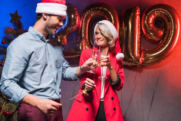 Jóvenes empresarios tintineo con copas de champán en la fiesta corporativa de año nuevo - foto de stock