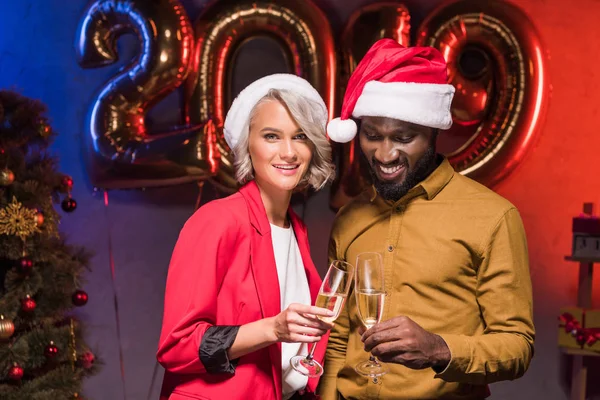 Uomo d'affari afro-americano sorridente e donna d'affari caucasica alla festa aziendale di Capodanno — Foto stock