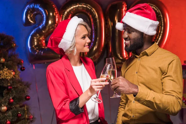Африканский американский бизнесмен и кавказская деловая женщина звонят в очках на новогодней корпоративной вечеринке — стоковое фото