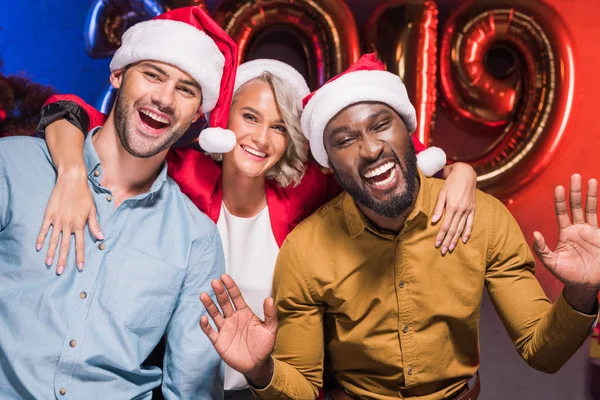 Felices empresarios multiculturales mirando a la cámara en la fiesta corporativa de año nuevo - foto de stock
