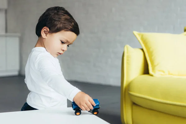 Чарівна дитина грає з іграшковим автомобілем вдома — стокове фото