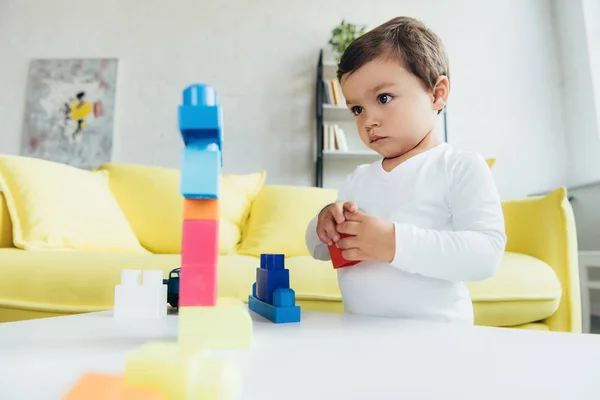 Adorable garçon jouer avec des blocs de constructeur colorés à la maison — Photo de stock