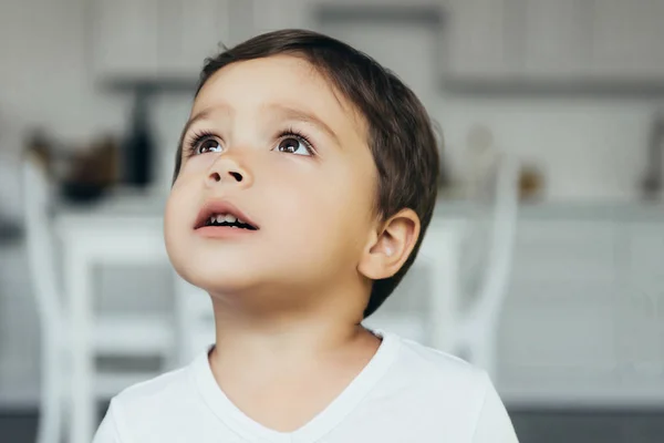 Porträt eines entzückenden unschuldigen Jungen, der zu Hause aufschaut — Stockfoto