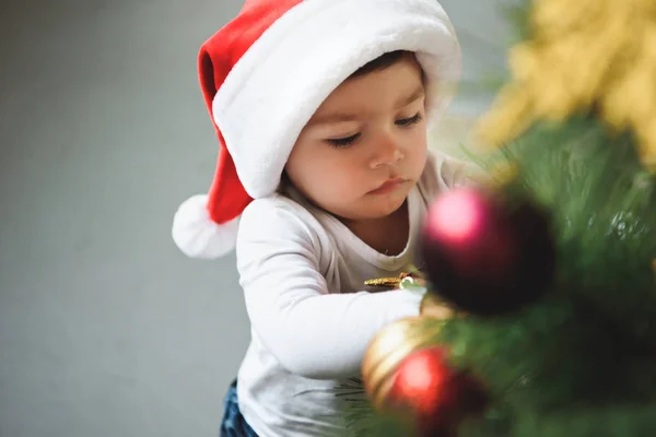 Adorable petit garçon en chapeau de Père Noël décorant arbre de Noël — Photo de stock